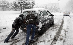 People push their car during a heavy snowfall in Marseille as winter weather continues in France January 7, 2009. Heavy snowfall in Marseille forced the international airport to close and paralysed all train and bus traffic on Wednesday in the country's second-biggest city.