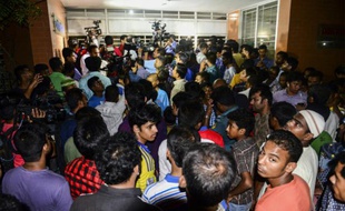 Des journalistes bangladais et des badauds sont rassemblés devant l'immeuble où deux personnes ont été assassinées, dont un militant gay, à Dacca, le 25 avril 2016