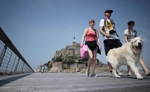 Des touristes sur le pont-passerelle menant au Mont-Saint-Michel (Manche), le 22 juillet 2014