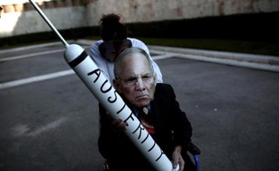 Un manifestant grec arborant un masque qui représente le ministre allemand des Finances Wolfgang Schaeuble, dénonce l'austérité lors d'un rassemblement devant le Parlement à Athènes le 15 février 2015