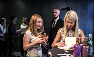 La youtubeuse Marie Lopez (d), alias EnjoyPhoenix, avec une fan en pleurs, le 17 juin 2015 à Lyon