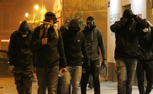 Un groupe d'hommes cagoulés marche le 14 février à Bastia lors d'un rassemblement en soutien à un supporteur du Sporting Club de Bastia blessé à Reims