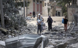 Une famille de réfugiés palestiniens retournent chez eux pour constater ce qu'il reste de leur maison après l'offensive israélienne, le 4 août 2014 près du camp de Rafah dans la bande de Gaza
