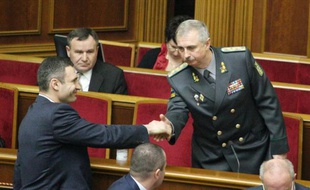Le leader d'opposition (Udar) Vitali Klitschko serre la main du nouveau ministre de la Défense Mykhailo Koval (d) au Parlement de Kiev, le 25 mars 2014