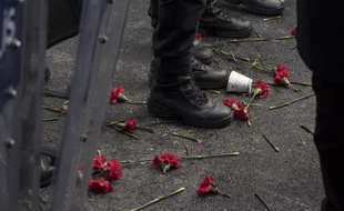 Des fleurs devant les pieds de policiers turcs faisant barrage devant la discothèque Reina où une attaque terroriste a fait 39 victimes et 65 blessés lors des célébrations du Nouvel An à Istanbul.