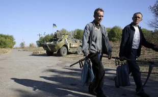 Des habitants de la ville de Gorlivka, dans l'est de l'Ukraine passent, le 18 septembre 2014, devant des militaires loyalistes