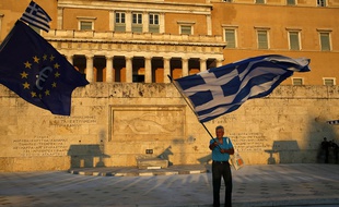 Des manifestants pro-euro agitent un drapeau grec et un drapeau européen devant le Parlement grec, à Athènes, le 9 juillet 2015.