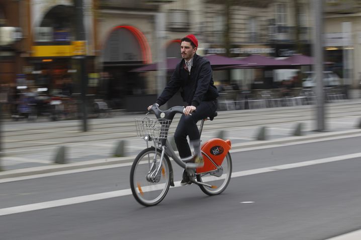 Un cycliste sur un vélo en libre-service cours des 50-Otages à Nantes.