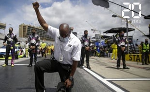 Un officiel de la compétition automobile Nascar, genou à terre, poing levé durant l'hymne de cette compétition, le 7 juin 2020 à l'Atlanta Motor Speedway à Hampton, en Géorgie, aux Etats-Unis