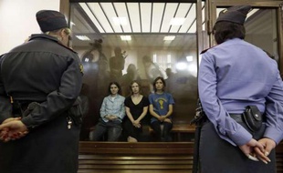 Les trois membres de Pussy Riot sont assises derrière une glasse de verre lors de leur procès, le 17 août 2012 à Moscou.