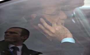 Le président François Hollande au téléphone dans sa voiture lors de sa visite de l'usine Michelin Ladoux à Cebazat près de Clemont-Ferrand, au centre de la France, le 18 avril 2014