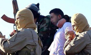 Image distribuée par le groupe Etat islamique aux sites islamistes montrant le pilote jordanien que l'EI a capturé en Syrie le 24 décembre 2014