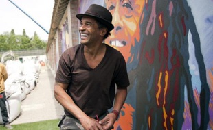 Yannick Noah devant un portrait de lui dans la cour de la maison d'arrêt de Fresnes (Val-de-Marne), le 2 juin 2014