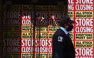 Un homme passe devant des magasins fermés, à New York, le 5 mai 2020.