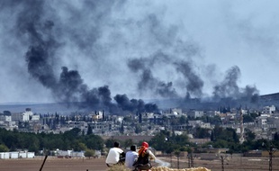 Des réfugiés kurdes regardent la ville de Kobané en proie au chaos, le 26 octobre 2014.