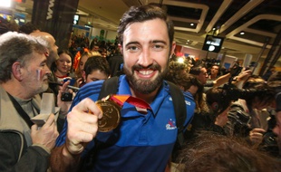 Le gardien de l'équipe de France Cyril Dumoulin savoure la médaille d'or ramenée du Mondial au Qatar lors du retour des Experts à l'aéroport de Roissy, le 2 février 2015.