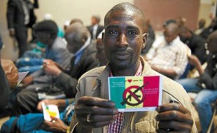 L'un des cent Maliens rassemblés mardi brandit le flyer de la manifestation prévue samedi.