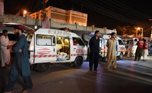 Des habitants se rassemblent le 30 mai 2015 devant l'hôpital de Quetta, dans le nord-ouest du Pakistan, autour d'une ambulance transportant les corps de victimes d'une attaque menéee par des hommes armés contre les passagers de deux cars