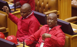 Julius Malema, right, leader of the Economic Freedom Fighters, EFF, sit inside the South African parliament as he and other members meet in Cape Town, South Africa, Thursday, Nov. 27, 2014. National Assembly Speaker Baleka Mbete called for the meeting of Parliament to complete outstanding matters before going into recess, after recent disagreements under members of parliament. (AP Photo/Schalk van Zuydam) /ASVZ103/765592698910/1411271452