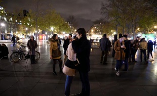 Un couple venu rendre hommage aux victimes des attentats de Paris, Place de la République à Paris, le 14 novembre 2015