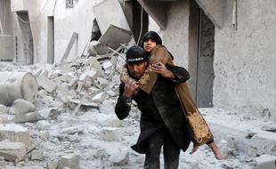 Un sauveteur syrien porte une rescapée d'un bombardement sur un quartier rebelle d'Alep, le 20 novembre 2016.