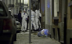 Des enquêteurs et policiers devant l'entrée de la mosquée chiite d'Anderlecht, à Bruxelles, après un incendie criminel, le 12 mars 2012