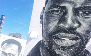 Des portraits de migrants réalisés par Al Sticking ont traversé la ville dimanche.