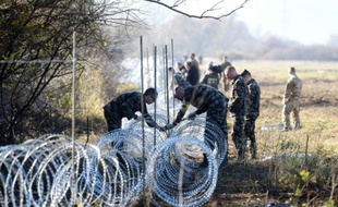 Des soldats slovènes installent une clôture en fil barbelé sur la frontière avec la Croatie, le 12 novembre 2015