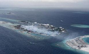 L'approche aérienne des Maldives offre une vue panoramique d'eaux azur et d'îles bordées de coraux mais à l'atterrissage, des volutes de fumée révèlent également un désastre environnemental.