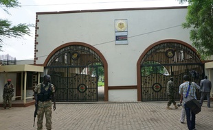 Des soldats montent la garde devant l'entrée du palais présidentiel à Juba, couverte d'impacts de balles, le 15 juillet 2016 au Soudan du Sud
