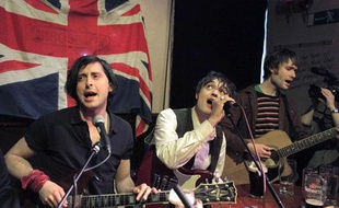 Les Libertines (de G à D, Cart Barat, Pete Doherty et John Hassall) en concert improvisé après avoir annoncé lors d'une conférence de presse la présence du groupe aux festivals de Leeds et Readings à l'été 2010, Londres, le 31 mars 2010.