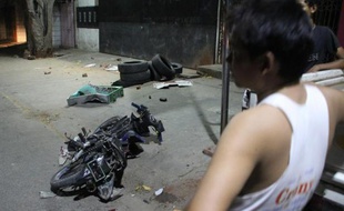 Un homme regarde une moto à terre après des violences entre bouddhistes et musulmans à Mandalay, en Birmanie, le 3 juillet 2014