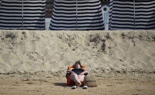 Deauville, le 1er juillet 2015. Une femme bronze sur la plage.