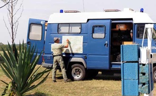 Un gendarme consulte une carte fixée sur une voiture de gendarmerie stationnée en bordure de la forêt de Othe, le 9 septembre 2009 près de la commune de Joigny où se déroulent les recherches pour retrouver Jean-Pierre Treiber.