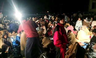 Des gens se réunissent dans un abri devant la mairie de Mashiki, dans la préfecture japonaise de Kumamoto après un tremblement de terre, le 14 avril 2016