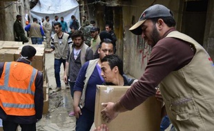 Des travailleurs humanitaires apportent de l'aide alimentaire dans le camp de réfugiés de Yarmuk près de Damas, le 11 mars 2015