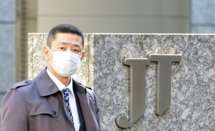 Un passant devant le siège de Japan Tobacco à Tokyo le 15 mars 2013