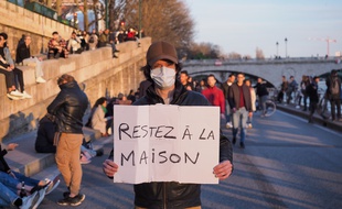 Un homme à Paris, le 15 mars 2020, incitant les habitants à rester chez eux face au coronavirus.
