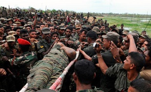 Le corps présumé du chef historique des Tigres de libération de l'Ealam tamoul (LTTE), Velupillai Prabhakaran, est transporté sur un brancard parmi des soldats sri-lankais, Mullaittivu, Sri Lanka, le 19 mai 2009.