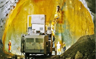 Dans le tunnel, une foreuse automatique effectue les trous qui recevront les explosifs sous forme de gel.
