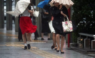 Des piétons marchent dans les rues de Hamamatsu (centre du Japon) frappé par le typhon Etau, le 9 septembre 2015