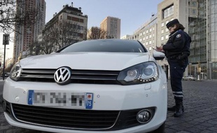 Un policier contôle un automobiliste le 23 mars 2015 à Paris où la circulation alternée est entrée en vigueur