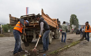 A Mitrovica, des ouvriers retirent une barricade installée il y a trois ans pour empêcher l'accès des Kosovars albanais, le 18 juin 2014