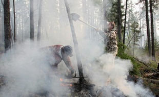 Des pompiers tentent d'étteindre un feu dans la taïga sibérienne en Russie, le 29 août 2015 près de la ville d'Irkutsk