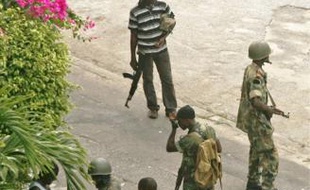 Des partisans du président sortant, Laurent Gbagbo, contrôlent un homme à proximité du palais présidentiel, hier à Abidjan.