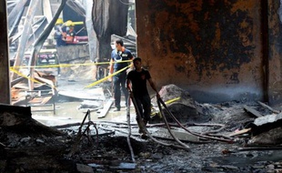 Pompiers au milieu des décombres après l'incendie d'une fabrique de chaussures, le 14 mai 2015 à Manille