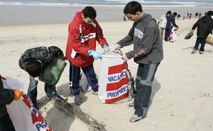 Des élèves du collège Capeyron de Mérignac ramassent des détritus sur la plage sud de Lacanau-Océan, le 17 mars 2006, lors d'une opération de collecte des déchets organisée par Surfrider Foundation Europe.