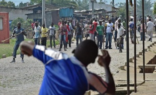 Un manifestant hostile à un 3e mandat de Pierre Nkurunziza lance une pierre en direction de membres de l'aile pour la jeunesse du parti au pouvoir, dans une banlieue de Bujumbura, le 25 mai 2015