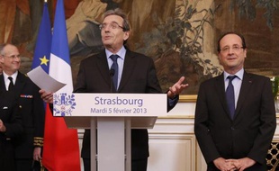French President Francois Hollande (R) listens to a speech by Strasbourg's mayor Roland Ries (C) after their meeting at Strasbourg's town hall, on February 5, 2013. AFP PHOTO POOL CHRISTIAN HARTMANN