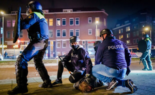 Des policiers néerlandais arrêtent un émeutier anti-couvre-feu le 25 janvier 2021 à Rotterdam, aux Pays-Bas.